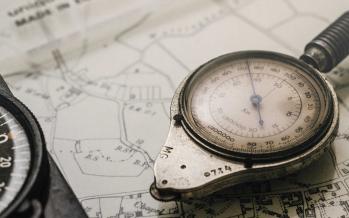 Shallow focus photography of black and silver compasses on