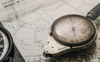 Shallow focus photography of black and silver compasses on